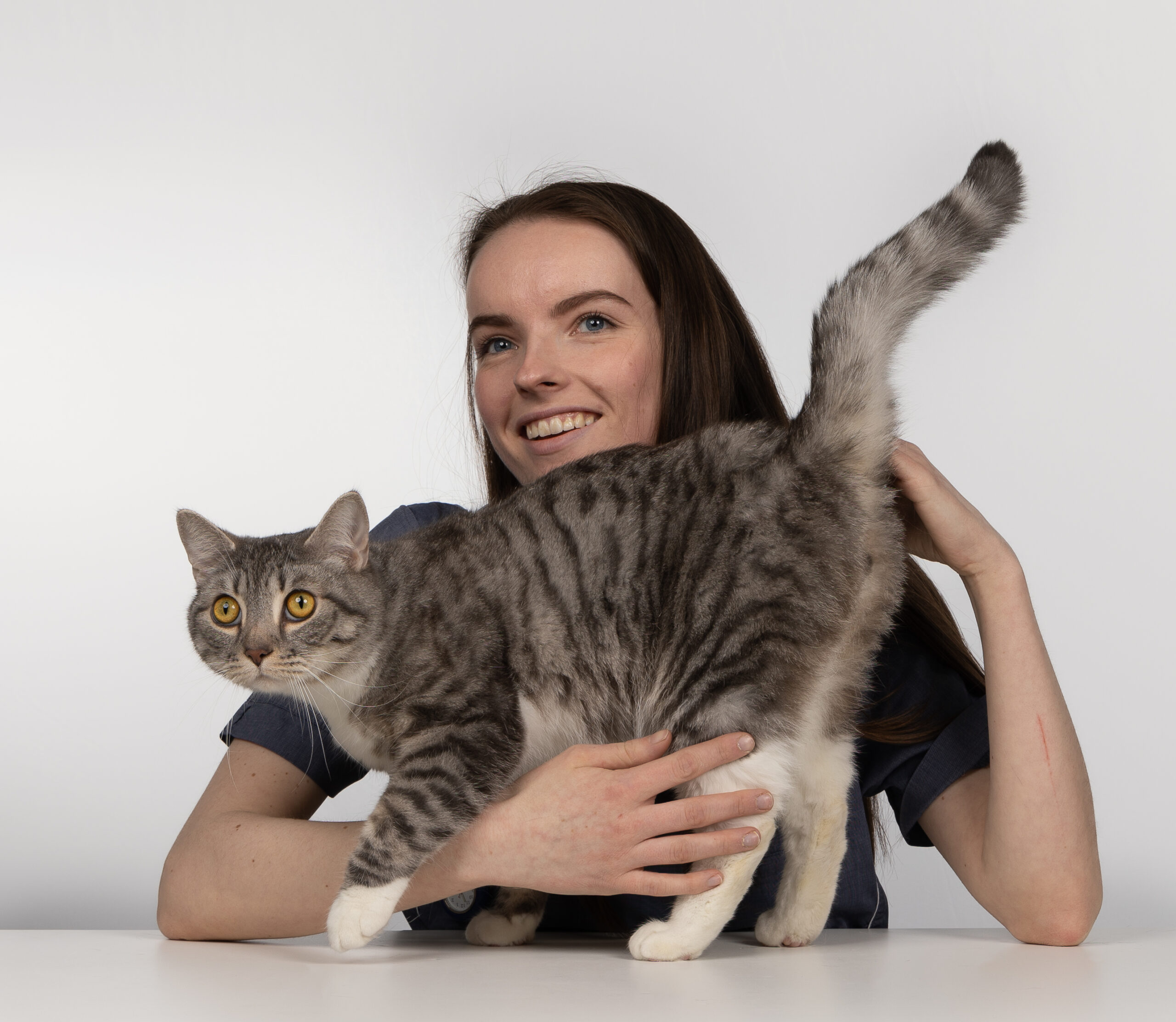 En dame som holder en katt i armene hennes.